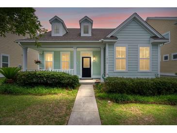 Charming one-story home featuring a covered front porch, dormer windows, and mature landscaping at 1870 Gammon St, Charleston, SC 29414