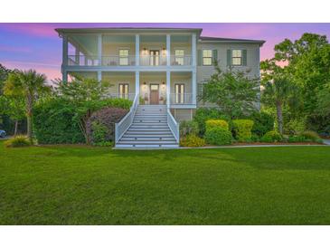 Stunning two-story home with double porches, lush landscaping, and a vibrant green lawn at 2269 Hartfords Bluff Cir, Mount Pleasant, SC 29466