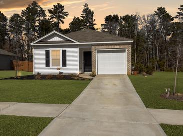 Charming single-story home featuring brick and siding accents, plus a well-maintained lawn and attached garage at 386 Spruce Ivy St, Moncks Corner, SC 29461