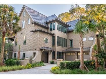 A beautiful custom home features a large front yard, a circle window and a 3 car garage at 515 Claret Way, Kiawah Island, SC 29455