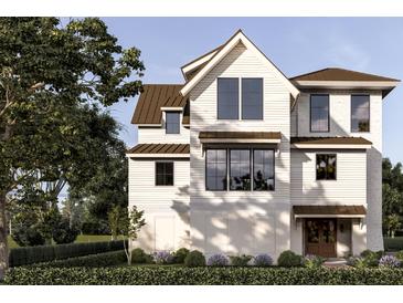 Charming two-story home with a gabled roof, light siding, large windows and meticulously landscaped front yard at 13 Trumbo St, Charleston, SC 29401