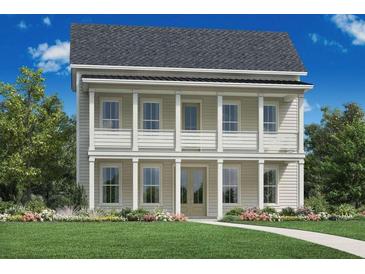 Charming two-story home boasts double balconies, columns, a manicured lawn, and beautiful landscaping at 148 Falaise St, Charleston, SC 29492
