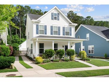 Charming two-story home featuring white siding, blue shutters, and a welcoming front porch at 3203 Moonlight Dr, Charleston, SC 29414
