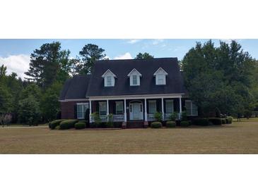 Charming brick home featuring a covered porch, manicured lawn, and classic architectural details at 351 Duncan Chapel Rd, Harleyville, SC 29448