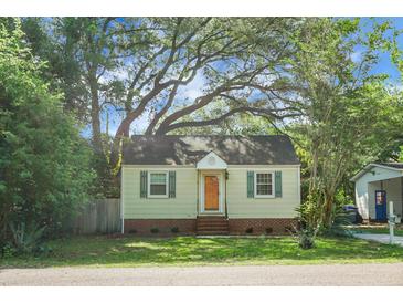 Charming single-story home featuring a well-manicured lawn, mature trees, and a classic architectural design with shutters on the windows at 4810 Parkside Dr, North Charleston, SC 29405