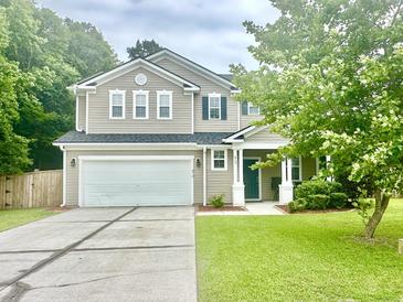 Charming two-story home boasts a well-manicured lawn and attached two car garage at 610 Knowledge Dr, Ladson, SC 29456