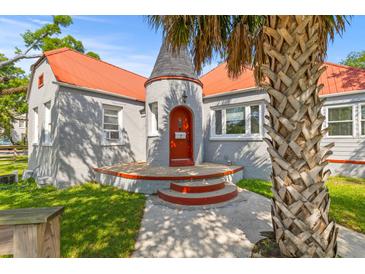 Charming home with a unique turret entrance, red door, orange roof, gray brick, and mature palm tree at 7 Wesley Dr, Charleston, SC 29407