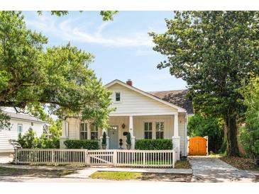 Charming white cottage with a picket fence and lush landscaping, showcasing classic curb appeal at 814 Rutledge Ave, Charleston, SC 29403