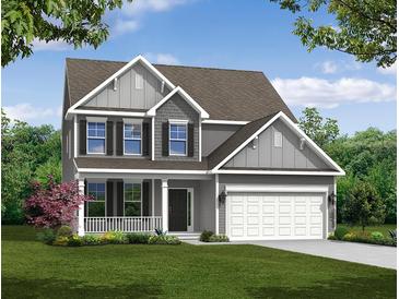 Charming two-story home featuring a covered porch, attached two-car garage, and beautifully landscaped front yard at 114 Shingle Oak Dr, Moncks Corner, SC 29461