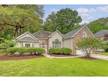 Charming home featuring a manicured lawn, lush landscaping, and a blend of brick and siding on the exterior at 1148 Black Rush Cir, Mount Pleasant, SC 29466