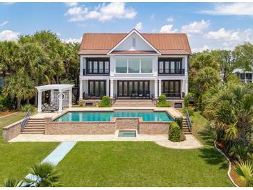 Stunning backyard with a large pool, outdoor seating, and lush landscaping perfect for entertaining at 104 Beach St, Mount Pleasant, SC 29464