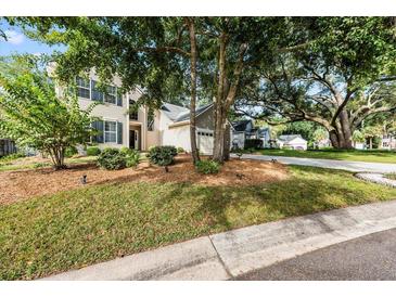 Charming two-story home featuring lush landscaping, mature trees, and a well-maintained lawn in a serene neighborhood at 1330 Somersby Ln, Mount Pleasant, SC 29466