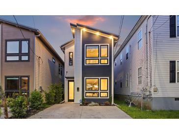 Modern home featuring unique design, multiple windows, a concrete driveway, and stylish exterior lighting at 14 F St # B, Charleston, SC 29403