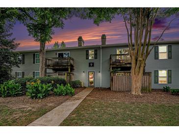 A charming two-story exterior view showcasing a well-maintained facade and landscaped front yard at 1402 Camp Rd # 9G, Charleston, SC 29412