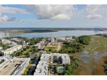 Stunning aerial view of community with waterfront, marsh views and a bridge in the background on a partially cloudy day at 145 Pier View St # 407, Charleston, SC 29492