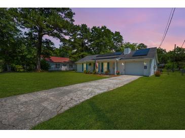 Charming single-story home featuring solar panels and a well-manicured lawn at 171 N Main St, Ridgeville, SC 29472