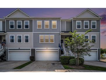Charming gray townhome with well-maintained lawn and attached garage at dusk at 185 Winding River Dr, Johns Island, SC 29455