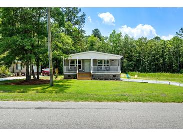 Charming single-story home featuring a covered front porch and well-maintained lawn at 208 General Moultrie Dr, Bonneau, SC 29431
