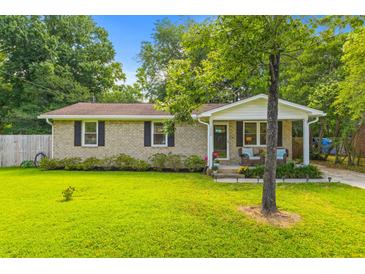 Charming brick home featuring a lush green lawn and inviting front porch with seating at 230 Azalea Ct, Moncks Corner, SC 29461