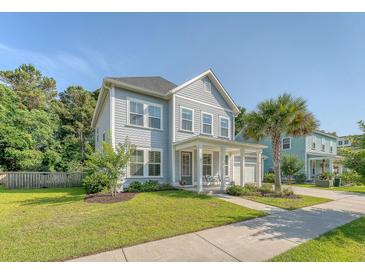 Charming two-story home with a manicured lawn and inviting front porch, enhanced by lush greenery at 2652 Private Lefler Dr, Johns Island, SC 29455