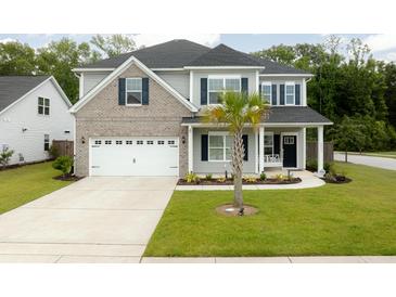 Charming two-story home featuring a two-car garage, landscaped yard and welcoming front porch at 2802 Cavalcade Cir, Johns Island, SC 29455