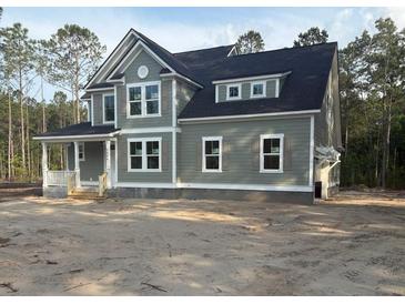 Two-story home featuring sage green siding, white trim, and charming dark shutters at 3006 Sweetwater Ln, Awendaw, SC 29429