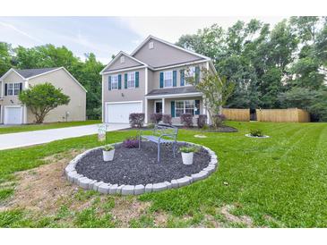 Charming two-story home with green shutters, a manicured lawn, and a decorative front yard at 3009 Mapleleaf Dr, Moncks Corner, SC 29461