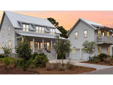 Inviting home showcasing its charming covered porch, well-manicured landscaping, and convenient two-car garage at 3023 Eventide Dr, Johns Island, SC 29455