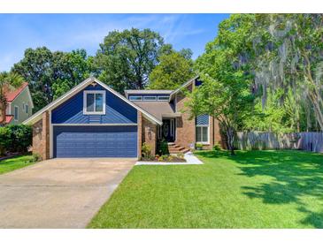 Charming two-story home features a two-car garage and a well-manicured lawn surrounded by mature trees at 310 Christiee Ct, North Charleston, SC 29418