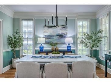 Stylish dining room features large windows, a modern chandelier, and seating for six at 3805 Adrian Way, Mount Pleasant, SC 29466