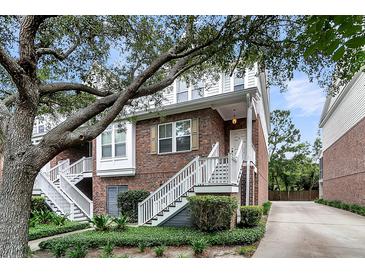 Charming brick townhome with white stairs, lush landscaping, and mature trees, offering curb appeal at 622 Windermere Blvd # D, Charleston, SC 29407