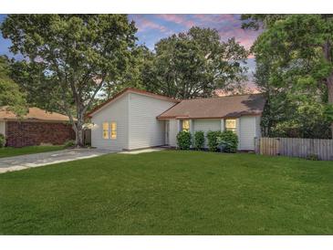 Charming one-story home featuring a green lawn, classic siding, and mature trees against a colorful sunset backdrop at 109 Salem Ct, Summerville, SC 29486