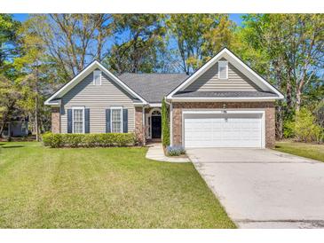 Charming single-story home featuring well-kept lawn, neutral siding, brick accents, and an attached two-car garage at 1179 Holly Bend Dr, Mount Pleasant, SC 29466