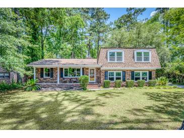 Charming brick home with lush green lawn and mature trees offers inviting curb appeal at 123 Azalea Dr, Summerville, SC 29485