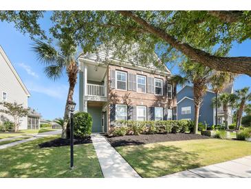 Charming two-story home with brick and siding, complemented by a landscaped front yard and a quaint second story balcony at 125 Gaslight Blvd, Summerville, SC 29483