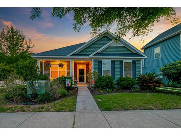 Charming home featuring manicured lawn, inviting front porch, and lush landscaping at 1589 Seabago Dr, Charleston, SC 29414