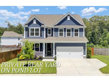Charming two-story home features a manicured lawn, blue siding, and a two-car garage at 203 Plowden Mill Ct, Summerville, SC 29485