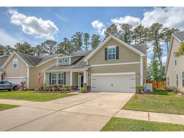 Charming home with a manicured lawn, flower beds, and a two-car garage at 227 Spectrum Rd, Summerville, SC 29486