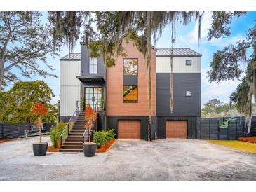 Striking modern home featuring mixed siding, a metal roof, a two-car garage, and a landscaped entrance at 231 Bayview Dr, Mount Pleasant, SC 29464