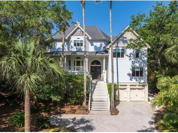 Charming two-story home features a well-manicured lawn, a two-car garage, and plentiful trees offering shade and privacy at 24 Beachwood West, Isle of Palms, SC 29451