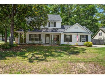 Charming two-story home with a landscaped yard, inviting front porch, and classic black shutters at 2916 Shadow Ln, North Charleston, SC 29406
