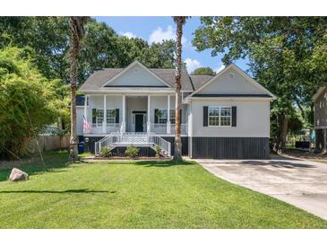 Charming two-story home featuring a welcoming porch, complemented by palm trees and a well-maintained lawn at 3872 James Bay Road Rd, Johns Island, SC 29455