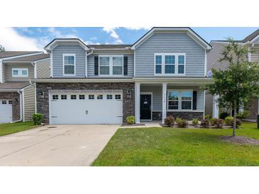 Charming two-story home featuring gray siding, stone accents, and a well-manicured lawn at 5138 Preserve Blvd, Ladson, SC 29456