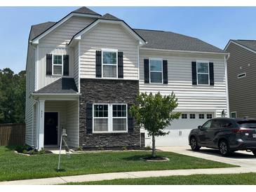 Charming two-story home with a combination of stone and siding exterior and manicured front yard at 677 Redbud Ln, Summerville, SC 29486