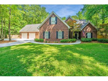 Charming two-story brick home with a well-manicured lawn, mature trees and a three-car garage at 69 King Charles Cir, Summerville, SC 29485