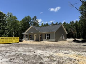 Charming single-story home with a covered front porch, gray siding, and black shutters nestled among green trees at 729 Burlington Rd, Walterboro, SC 29488