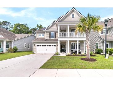 Charming two-story home features a front porch, attached garage, and a well-manicured lawn with a palm tree at 9829 English Elm St, Ladson, SC 29456