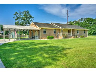 Charming single story brick home with covered parking and a well-manicured lawn in a suburban neighborhood at 101 Parkside Dr, Goose Creek, SC 29445