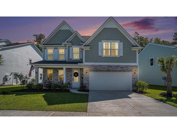 Charming two-story home boasts a mix of stone and siding, enhanced by a lush green lawn and twilight sky at 121 Cherry Grove, Summerville, SC 29483