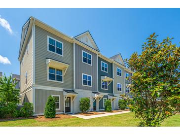 Stylish townhome exterior showing modern architecture, tidy landscaping, and a clear blue sky at 1242 Allusion Ln # 206, Mount Pleasant, SC 29466